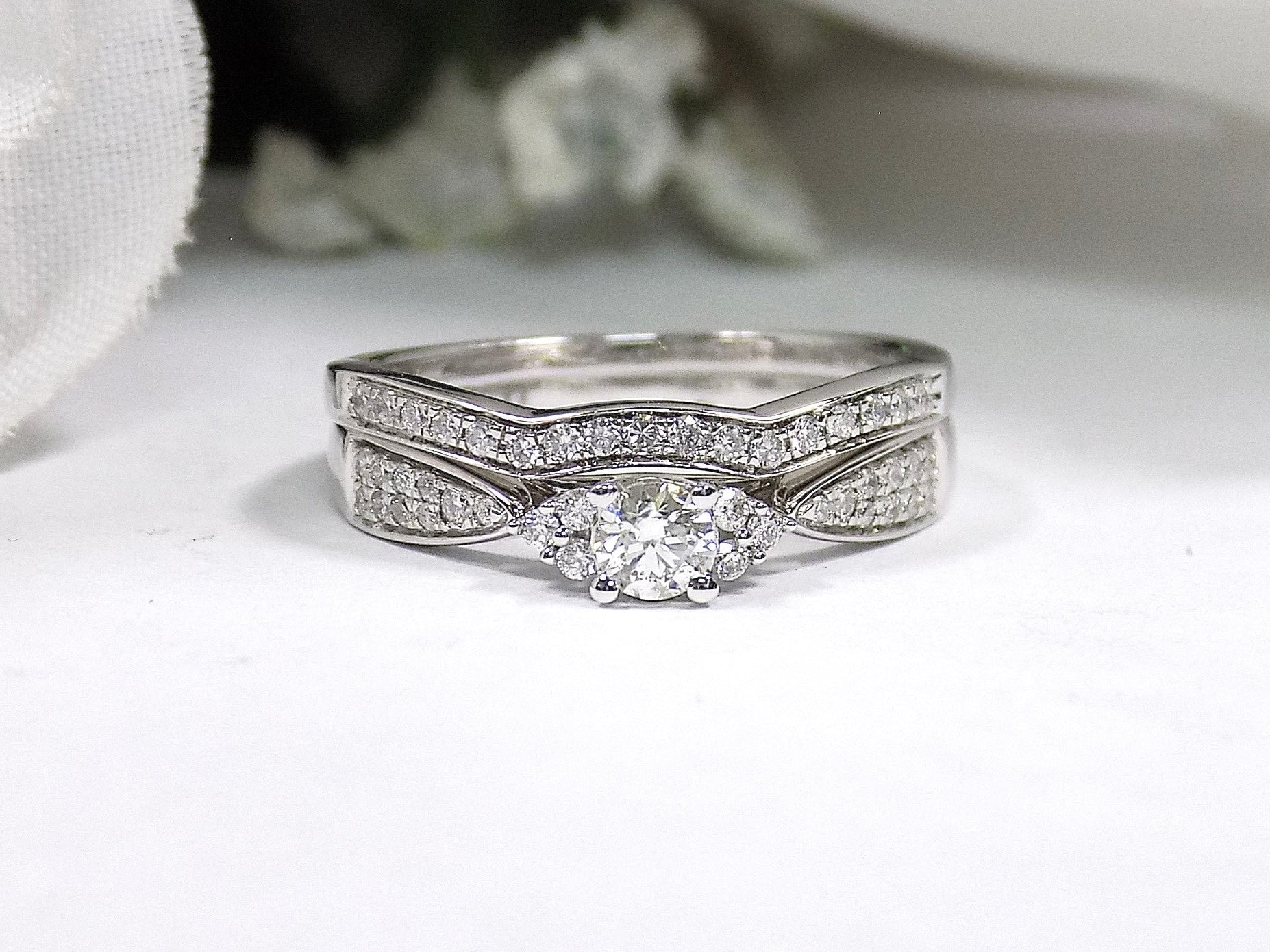This is a two piece diamond wedding set with the ring and matching band in white gold with white background. 