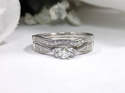 This is a two piece diamond wedding set with the ring and matching band in white gold with white background. 