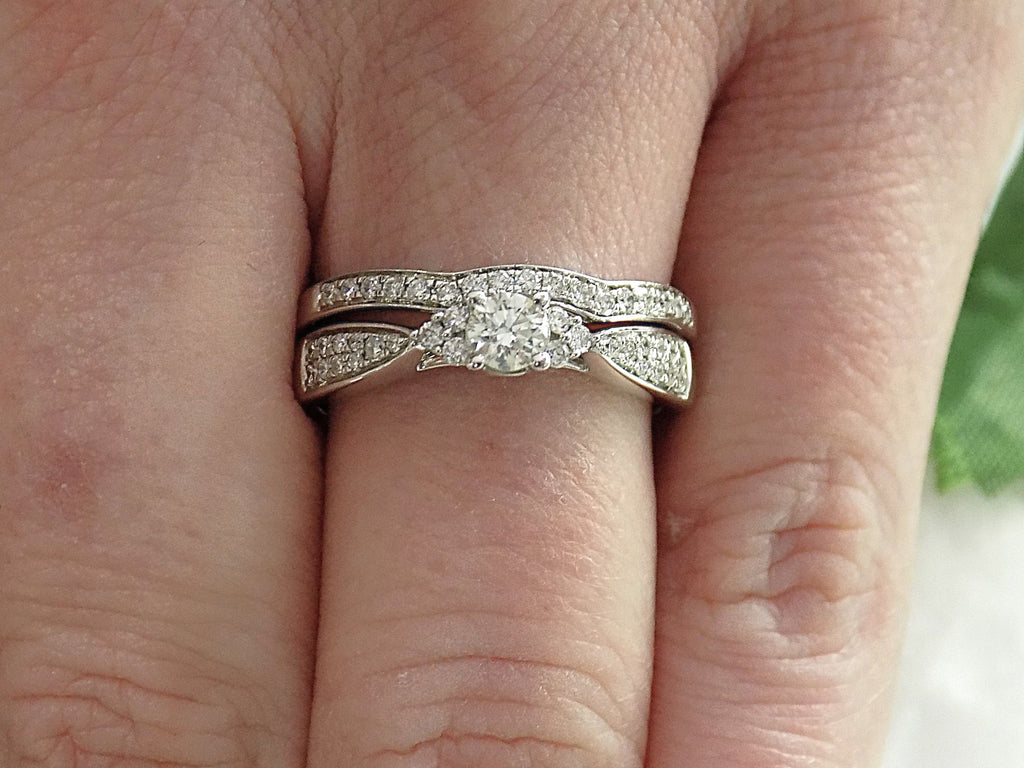 This is a two piece diamond wedding set with the ring and matching band in white gold shown on ladies' finger.