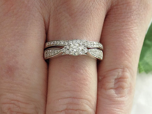 This is a two piece diamond wedding set with the ring and matching band in white gold shown on woman's finger.