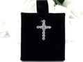 This is a .50ct natural diamond cross pendant in 14K white gold on a black pad with a white floral background.